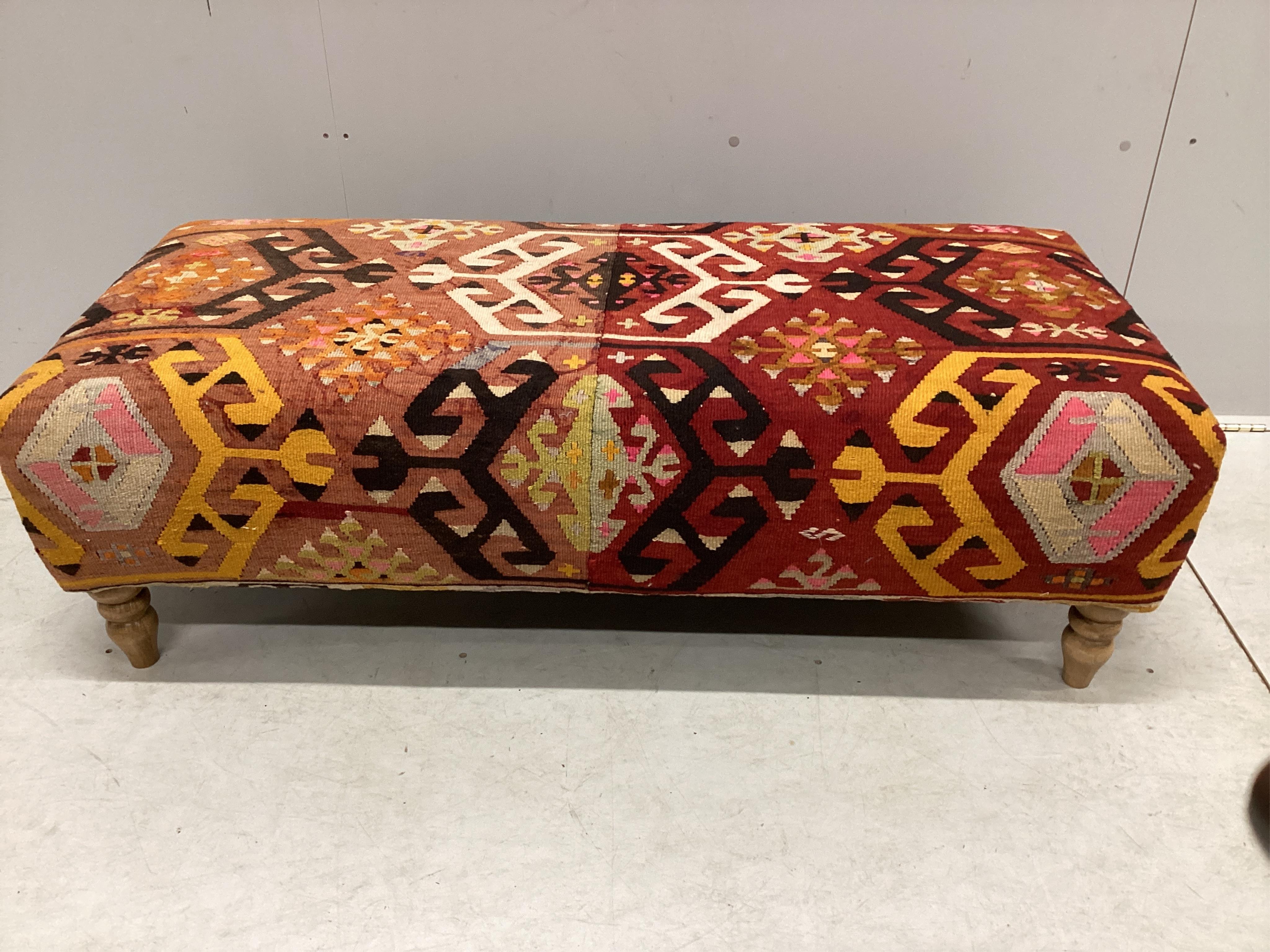 A large contemporary rectangular footstool with antique polychrome Kilim upholstery on turned beech feet, width 126cm, depth 58cm, height 40cm. Condition - good